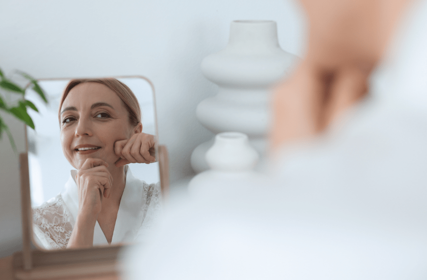 Femme se massant le visage devant un miroir